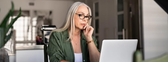 Eine Frau sitzt vor einem Laptop